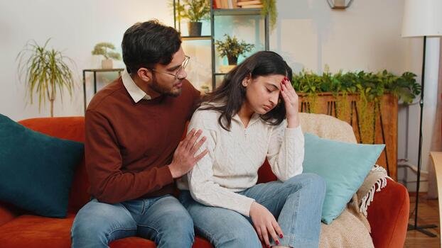 Man comforting upset partner at home, love problem solution consultation with astrologer Devraj Sharma