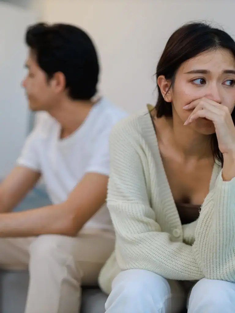 Couple sitting apart looking upset, marriage problem solution by astrologer Devraj Sharma